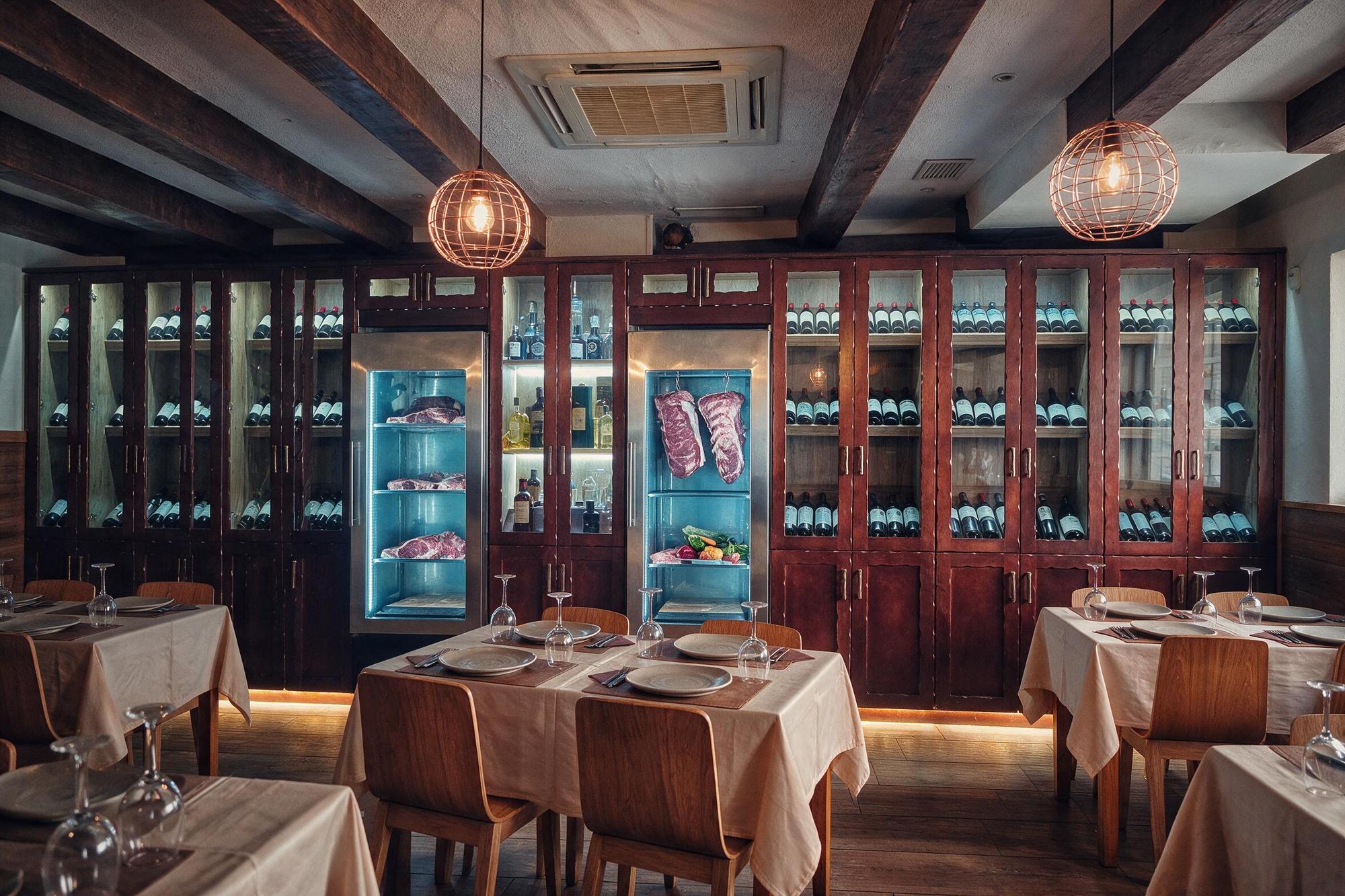 Interior del Restaurante El Quebracho con vigas de madera y cava de vinos